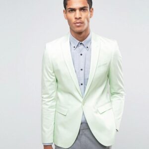 A man in a Cotton Sateen In Mint blazer and grey pants.