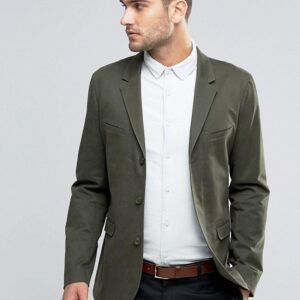 A man wearing a Washed Cotton in Khaki blazer and white shirt.