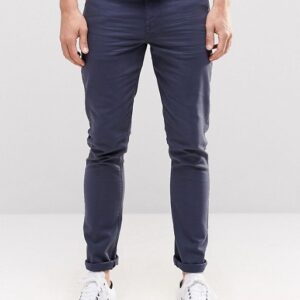 A man in a white t-shirt and blue Jeans In Dark chino pants.