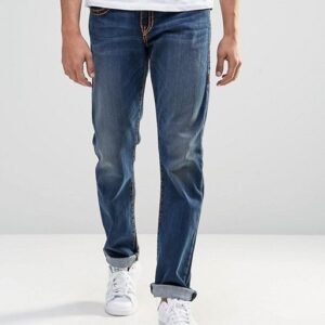 A man wearing Flap Super T Straight jeans and a white t - shirt.