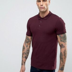 A man wearing a maroon polo shirt with tattoos.