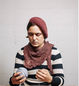 A woman knitting with a ball of yarn.
