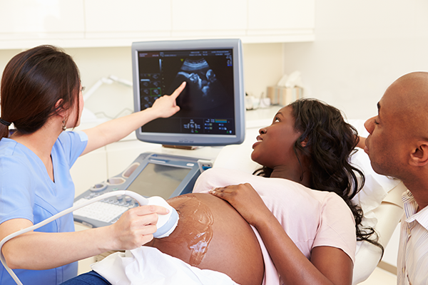 A pregnant woman is being examined by a doctor.