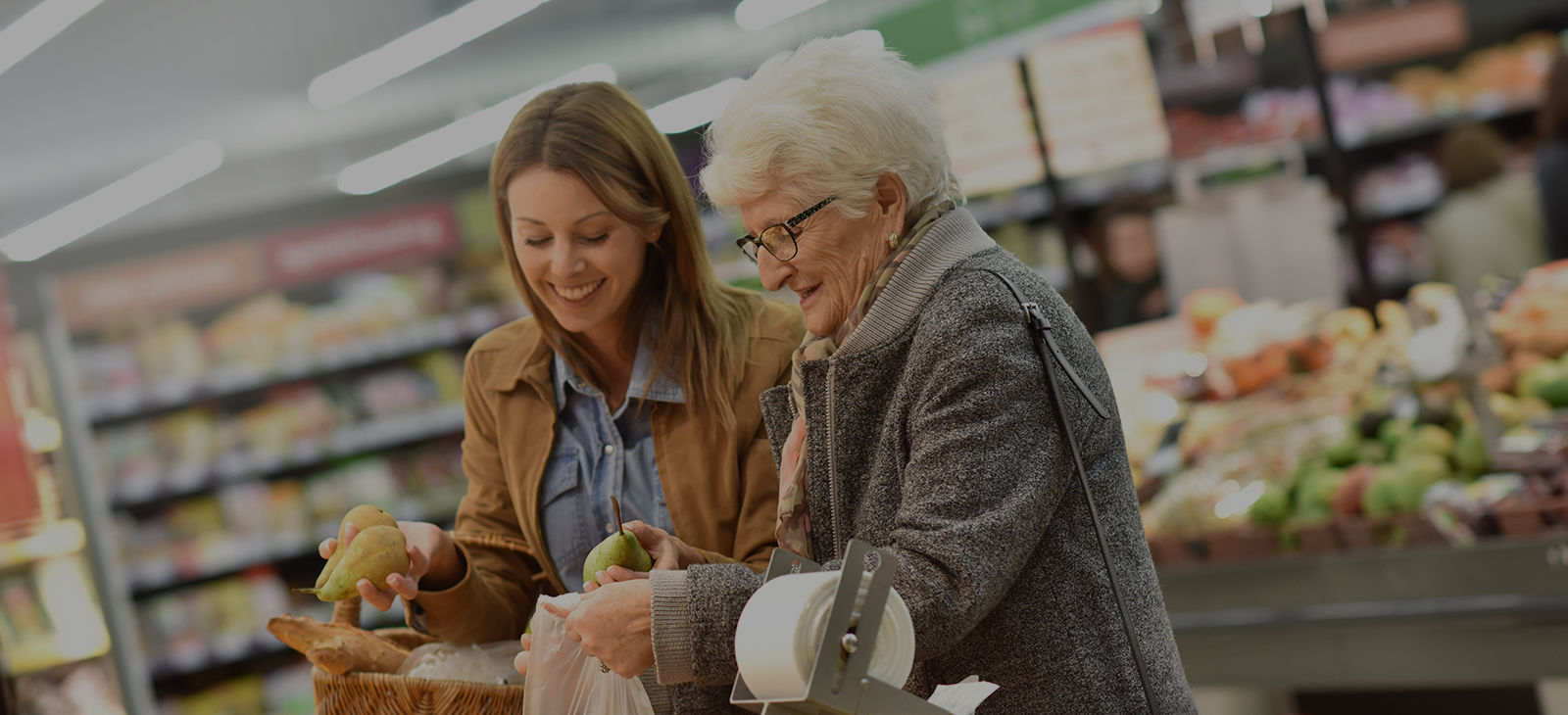 A woman and an elderly woman shopping in a grocery store.