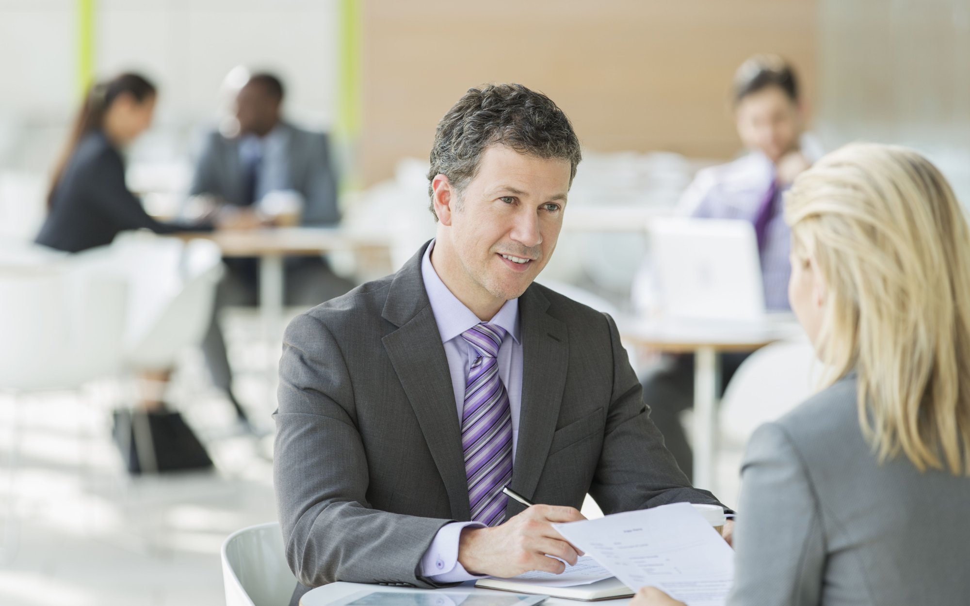 A businessman and woman talking in an office.